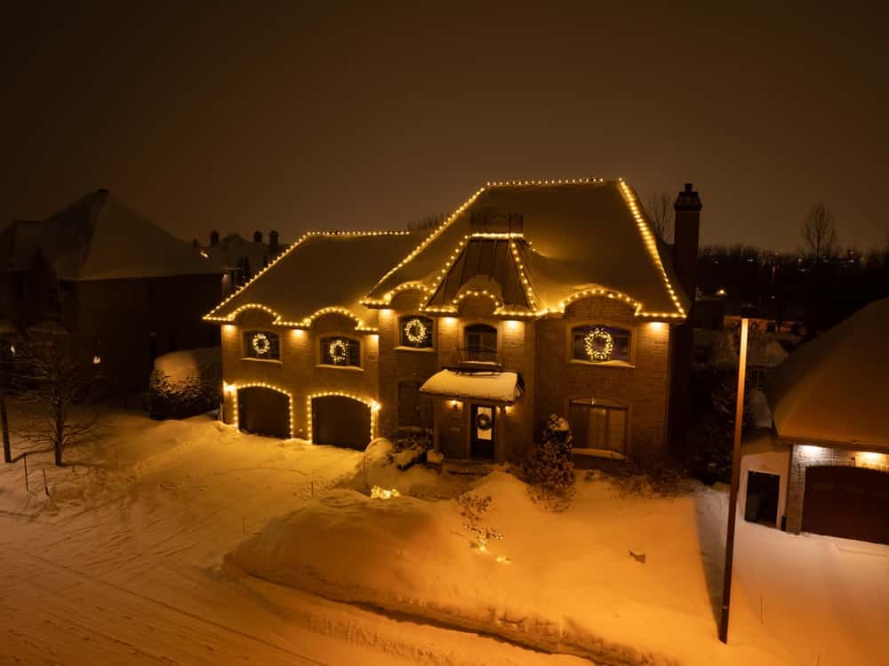 Éclairage festif — toiture et couronnes sous la neige